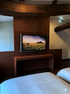 a bedroom with a flat screen tv on a wall at BLANKS - Vacation STAY 37519v in Taisha +2 photos
