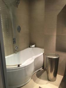 La salle de bains est pourvue d'une baignoire blanche et d'une poubelle. dans l'établissement Appartamento Vittoria, à Chamonix-Mont-Blanc