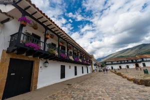 a cobblestone street in a town with buildings and flowers at Casa azul in Villa de Leyva