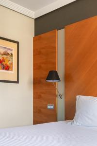 a bedroom with a bed and a wooden door at Dorma Juan de Austria in Valladolid