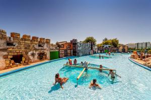 a group of people in a pool at a water park at Villa Vittoria in Lignano Sabbiadoro