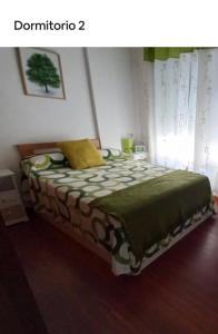a bedroom with a bed with a green blanket at Gavor 68 in A Pobra do Caramiñal