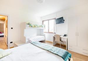 a white bedroom with a bed and a desk at B&B Castello Cimbergo in Cimbergo