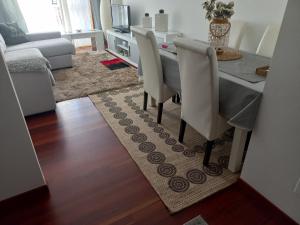 a dining room table and chairs in a living room at Gavor 68 in A Pobra do Caramiñal
