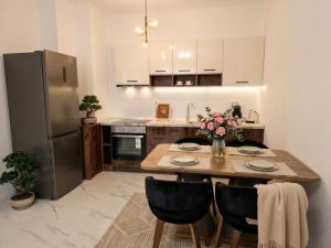 a kitchen with a wooden table and a refrigerator at Kasibel Suites in Sandanski