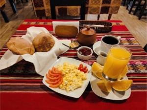 a table with a plate of breakfast food and orange juice at Hotel Golden Killa in Huaraz