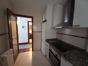 a small kitchen with a stove and a refrigerator at Gavor 68 in A Pobra do Caramiñal