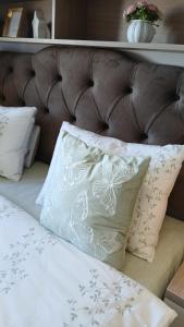 a bed with white pillows and a brown headboard at Koviljača apartman Demetrios in Banja Koviljača