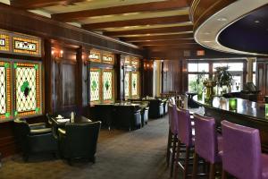 ein Restaurant mit lila Stühlen und einer Bar in der Unterkunft Queens Landing in Niagara on the Lake
