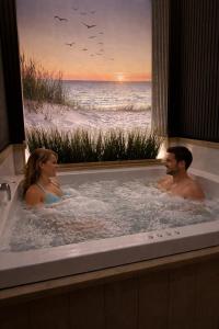 two people in a bath tub with a view of the beach at Zeeuws Ontspannen - Privé Wellness & Suites in Middelburg