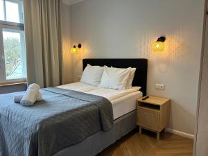 a bedroom with a bed with a night stand and a window at Jon`s Apartments in Pärnu