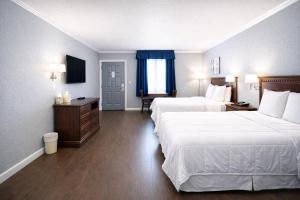 a hotel room with two beds and a television at Quarters Inn & Suites in Antioch