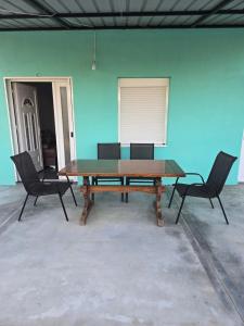 a table and chairs in a room with a blue wall at Olive Grove Retreat Podgorica in Vranj