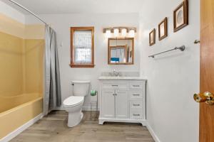 a bathroom with a toilet and a sink and a tub at HISA14: Sunny Daze in Salvo +21 photos