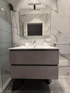 a bathroom with a sink and a mirror at Appartamento Laghetto in Segrate +18 photos