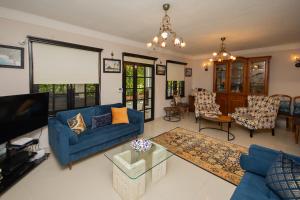 a living room with blue couches and a tv at Villa Cecilia in Göcek