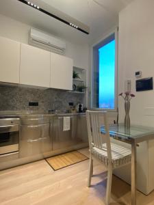 a kitchen with a table and a chair and a window at Appartamento Laghetto in Segrate