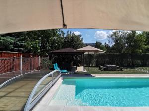 a swimming pool with a gazebo next to at Kovács Apartmanház in Balatonfüred