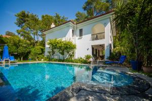 a swimming pool in front of a house at Villa Cecilia in Göcek