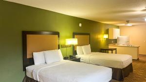 two beds in a hotel room with green walls at Studio 6 Chantilly VA Washington Dulles Airport in Chantilly +39 photos