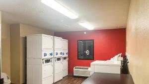 a room with white cabinets and a red wall at Studio 6 Chantilly VA Washington Dulles Airport in Chantilly