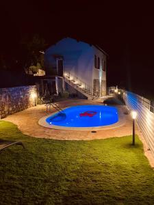 a large blue swimming pool in a yard at night at CASA AZZURRA in Imperia
