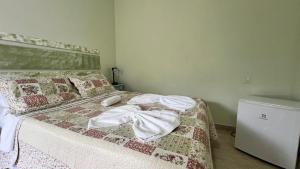 a bedroom with a bed with towels on it at Pousada Brisas da Serra in Serra do Cipo