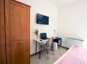 a bedroom with a desk with a laptop and a bed at Locanda del Borgo in Langa in Prunetto