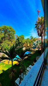 a view of a resort with chairs and palm trees at Pousada Brisas da Serra in Serra do Cipo