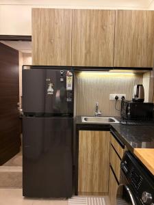 a kitchen with a black refrigerator and a sink at Casa Lobo in Mapusa