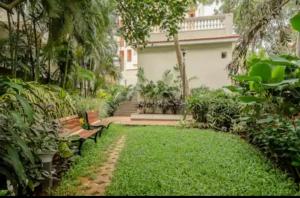 a garden with benches in front of a house at Casa Lobo in Mapusa