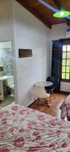 a bedroom with a bed and a table and chairs at Hotel Rancul Mamull Mapu in Rancul