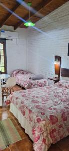 a bedroom with two beds with roses on them at Hotel Rancul Mamull Mapu in Rancul