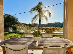 a table with two chairs and a palm tree at Villa SYAGRUS - Easy Home Booking in Nice