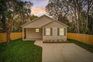a small house in a yard with a driveway at 1mi to Downtown! 3BR6BedsScreenroom,Deck,Firepit in St. Augustine