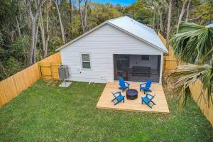 two blue chairs on a wooden deck in a backyard at 1mi to Downtown! 3BR6BedsScreenroom,Deck,Firepit in St. Augustine