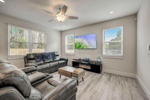 a living room with a couch and a ceiling fan at 1mi to Downtown! 3BR6BedsScreenroom,Deck,Firepit in St. Augustine +25 photos