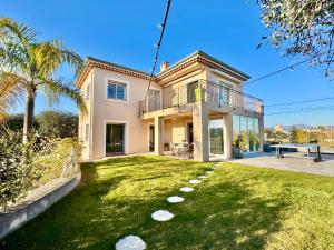 a large house with a yard with a table at Villa SYAGRUS - Easy Home Booking in Nice