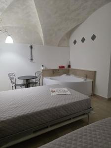 a bedroom with a bed and a table and a tub at La suite del Marchese a Vieste in Vieste +8 photos