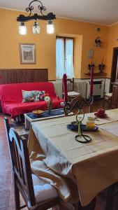 ein Wohnzimmer mit einem Tisch und einem roten Sofa in der Unterkunft Sor Mimi in Ascoli Piceno + 31 Fotos