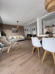 a living room with white chairs and a table at Schöfferles Ferienwohnung mit Sauna in Keidelheim