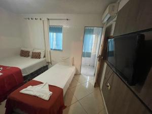 a hotel room with two beds and a flat screen tv at Pousada Casamar in Maceió