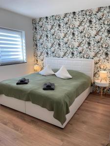 a bedroom with a bed with two hats on it at Schöfferles Ferienwohnung mit Sauna in Keidelheim