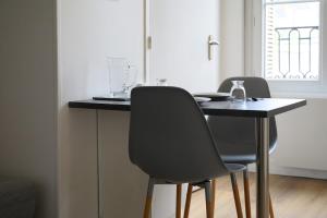 a dining room table with two chairs and a black table at Le Parvis - Studio cosy hyper centre - Proche gare in Tours