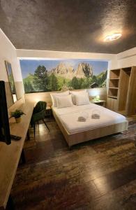 a bedroom with a bed with a painting on the wall at Pensiunea Carina in Bran