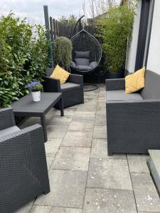 a patio with wicker chairs and tables and a swing at Schöfferles Ferienwohnung mit Sauna in Keidelheim