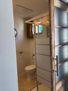 a bathroom with a toilet and a glass door at l'atelier by Emma in Bommes +9 photos