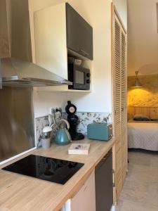 a kitchen with a stove top oven next to a bed at l'atelier by Emma in Bommes