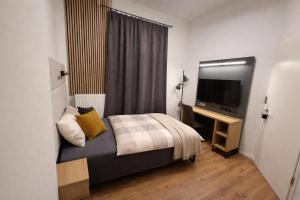 a bedroom with a bed and a flat screen tv at BASSWOOD ROOMS in Bremen
