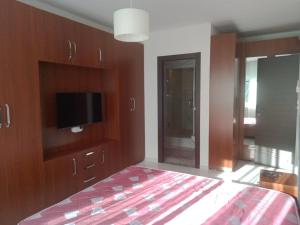 a bedroom with a bed and a flat screen tv at L'appartement en face de la baie in Sidi MʼHamed